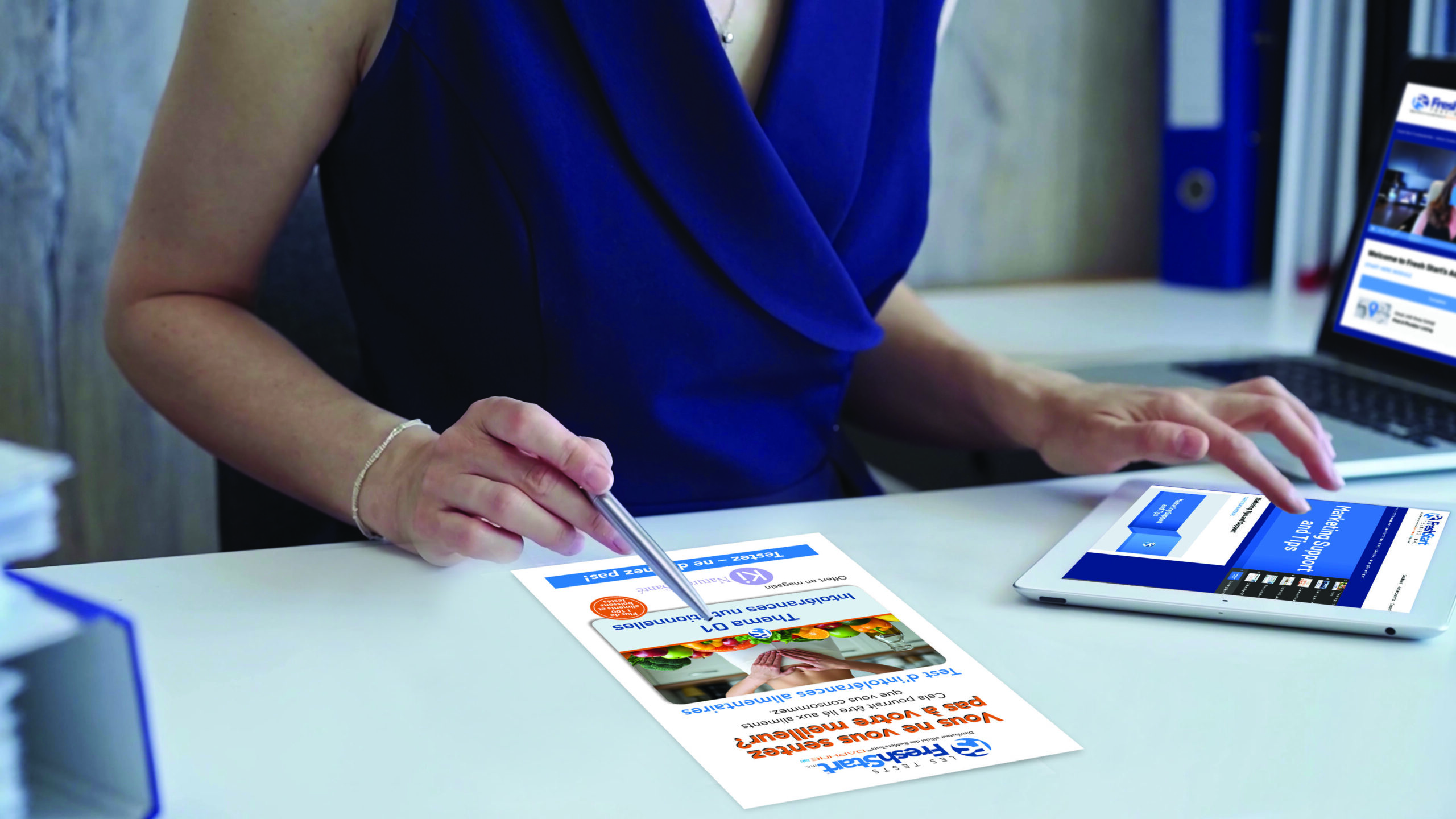 Businesswoman with dark blue dress is reviewing financial reports and pointing at a chart with a pen. Business concept